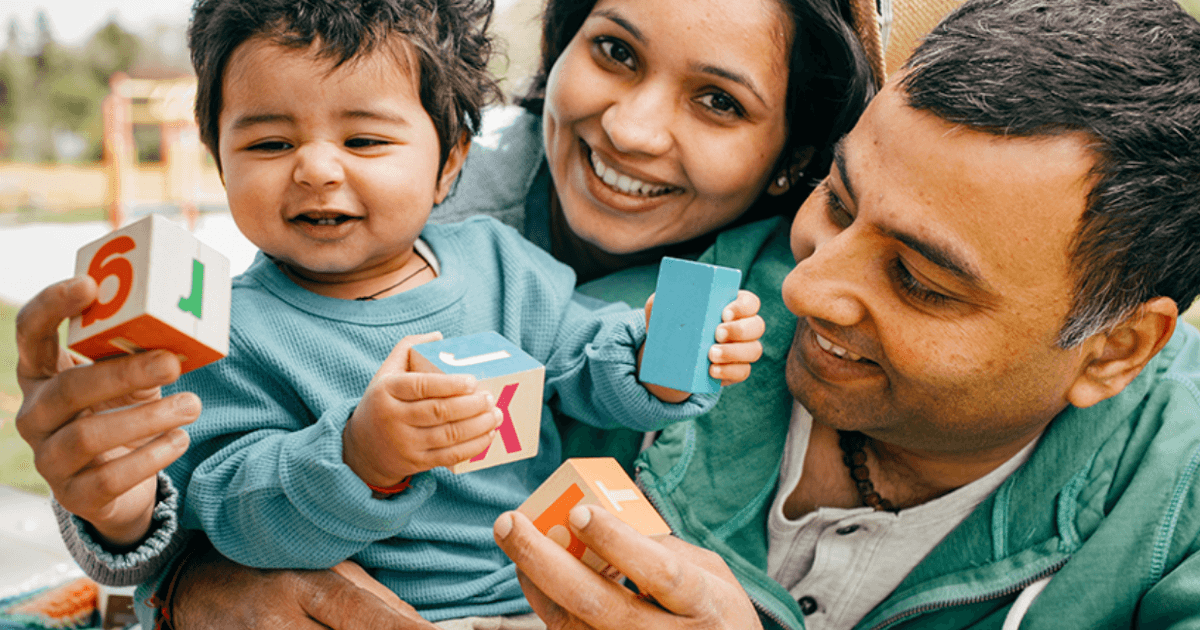 family with child playing with building blocks